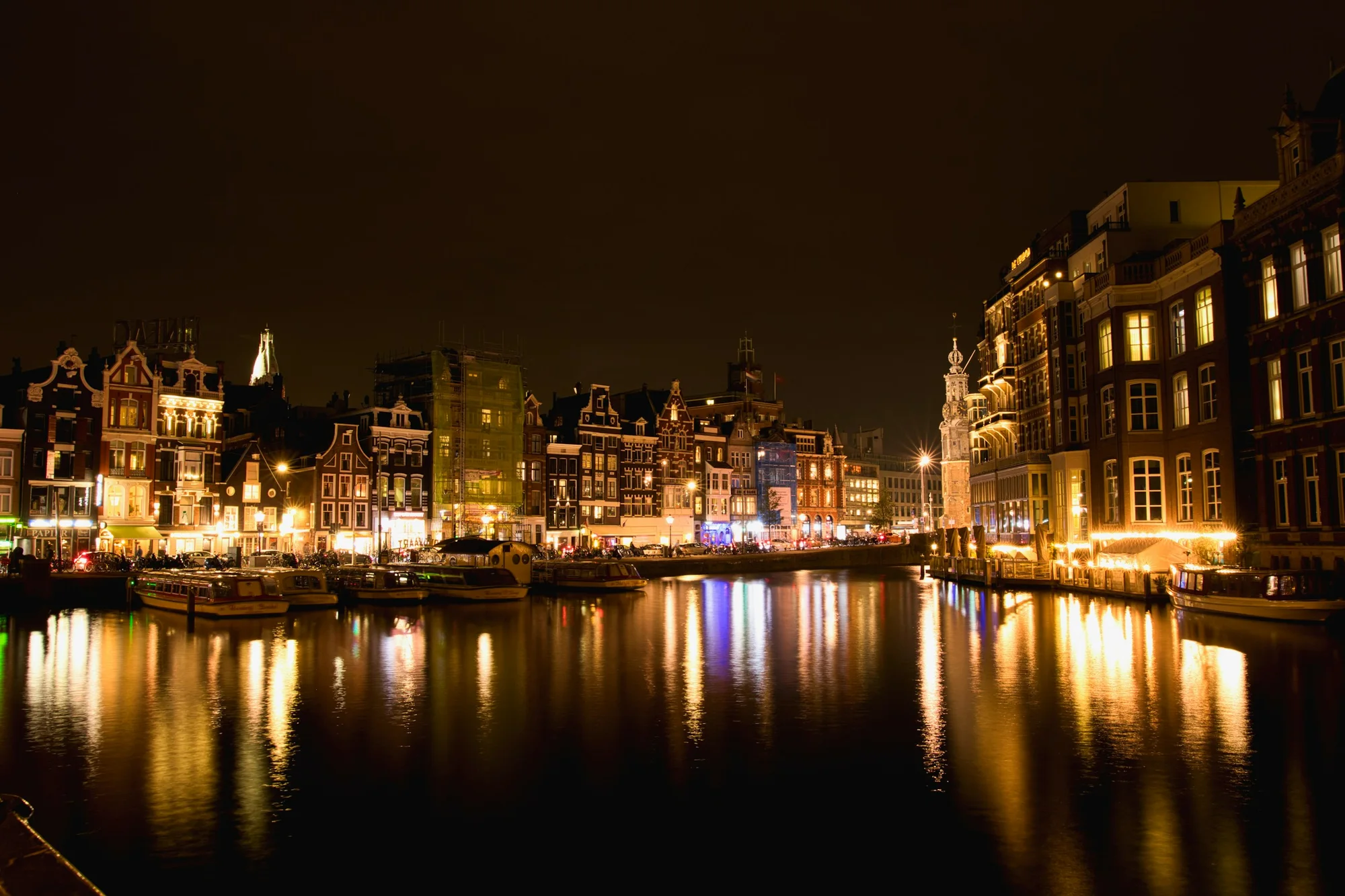 Amsterdam canal houses and bridges reflected in the water at night