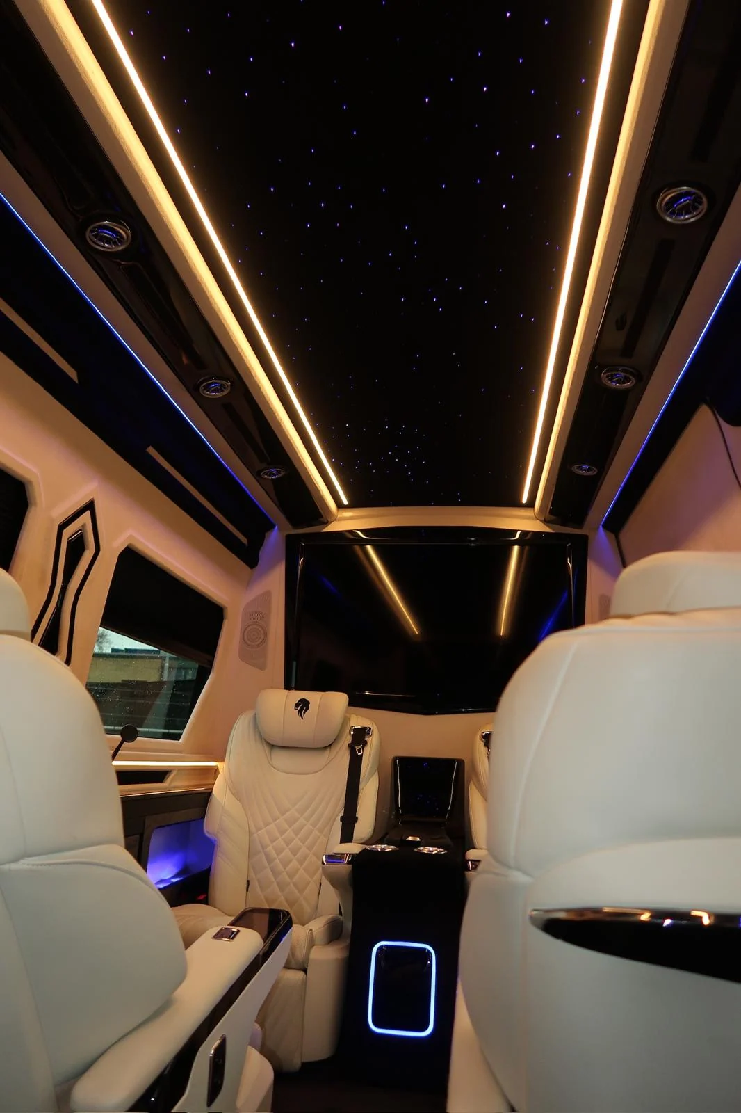 Warm-white starlight ceiling above the aisle and white seats