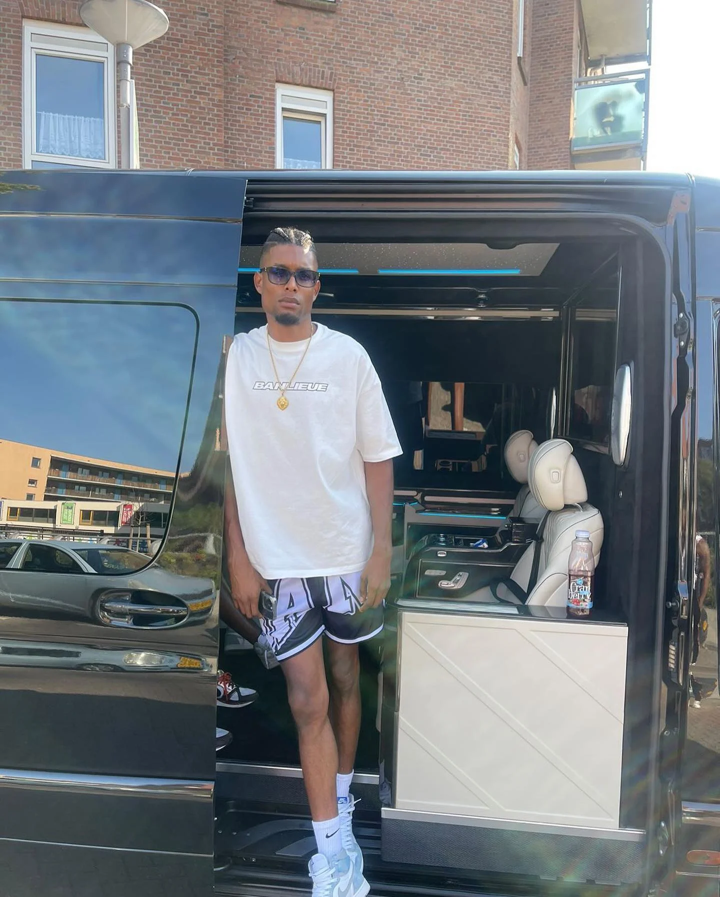 A person beside the open door of a black VIP vehicle